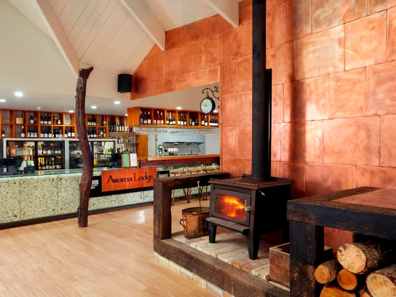 Hotelbar mit Kamin in der Lodge Unterkunft im Abel Tasman Nationalpark in Neuseeland.