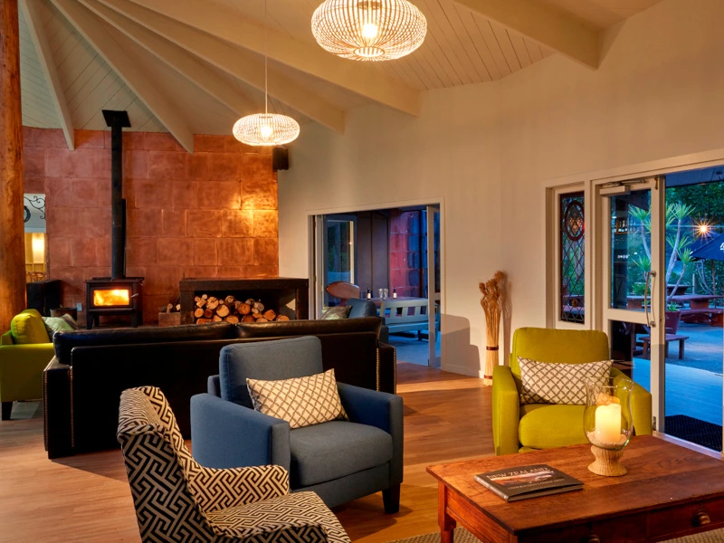 Sitzlounge mit Kamin in der Lodge Unterkunft im Abel Tasman Nationalpark in Neuseeland