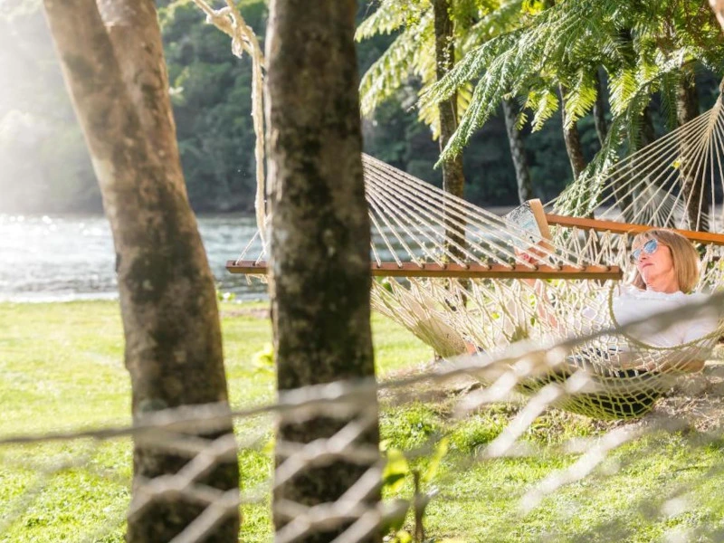 Frau entspannt in einer Hängematte in der Unterkunft bei den Marlborough Sounds in Neuseeland.