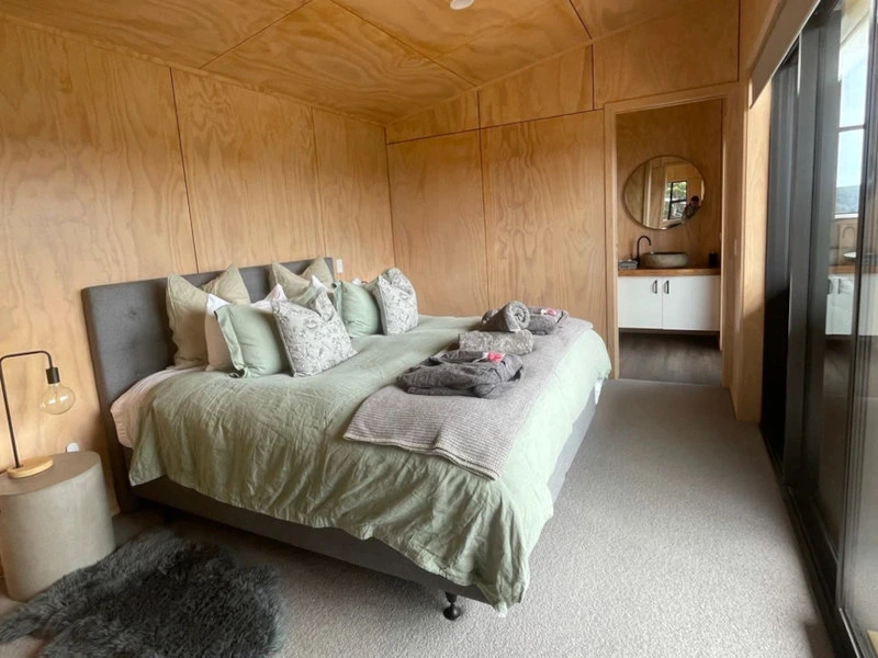 Gemütliches Schlafzimmer mit anliegendem Bad in der Cabin in den Catlins, Neuseeland