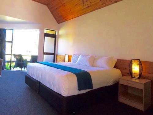 Großes Bett in gemütlichem Hotelzimmer in Omapere