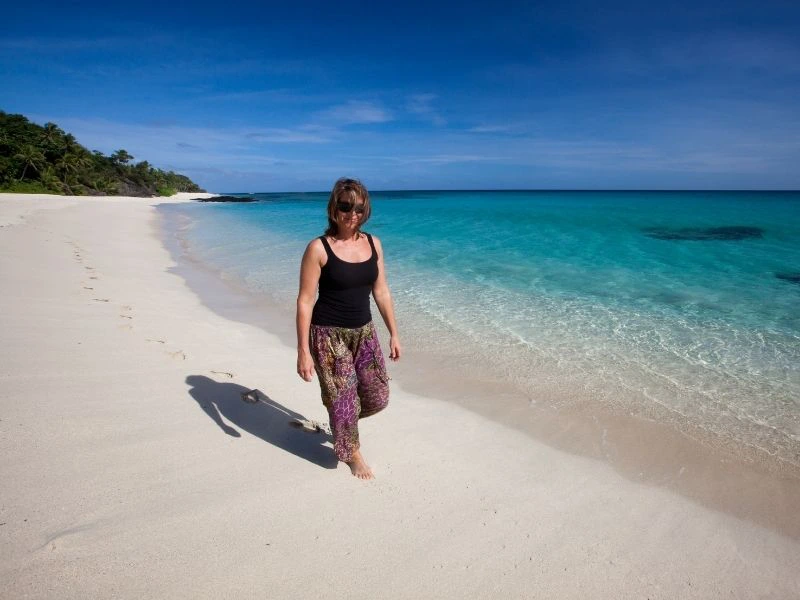 Frau spaziert am Strand entlang auf den Yasawa Inseln, Fidschi