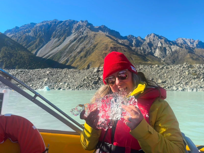 Frau mit Eis in der Hand bei Bootstour am Mount Cook in Neuseeland