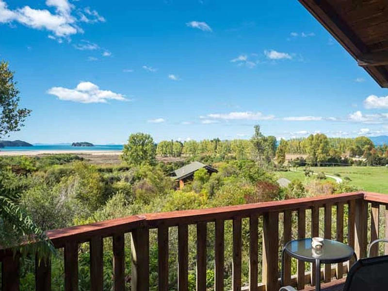 Holzterrasse am Chalet mit Blick aufs Meer und den Abel Tasman Nationalpark in Neuseeland