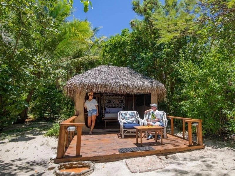 Personen entspannen auf Holzterrasse vor dem Bungalow auf den Yasawa Inseln, Fidschi