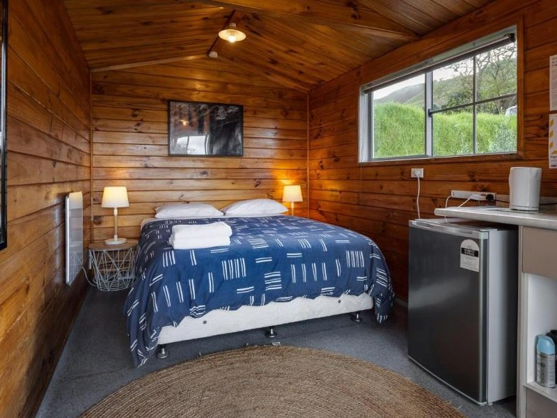 Schlafzimmer in mit Holz verkleideter Cabin in Gisborne, Neuseeland