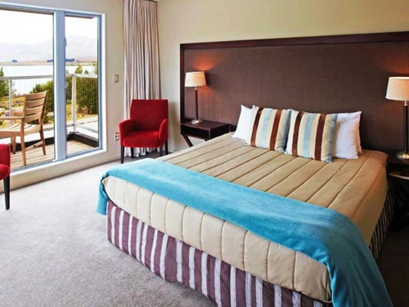 Gemütliches Bett im Hotelzimmer mit angrenzendem Balkon