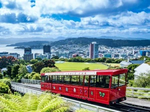Rotes Cable Car mit der Skyline von Wellington in Neuseeland im Hintergrund.