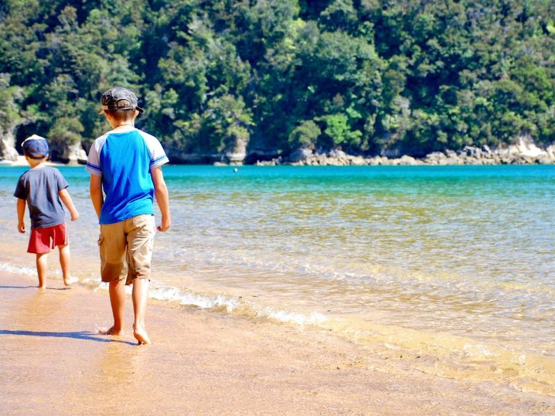 Kinder laufen am Strand im Abel Tasman Nationalpark, Neuseeland