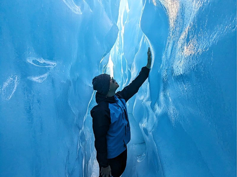 Person bestaunt das Eis auf einer Gletscherwanderung in Neuseeland.