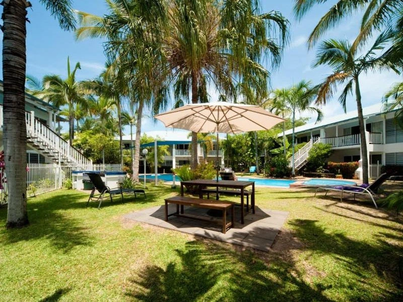 Pool umgeben von Liegen, Sonnenschirmen und Palmen in Airlie Beach, Australien