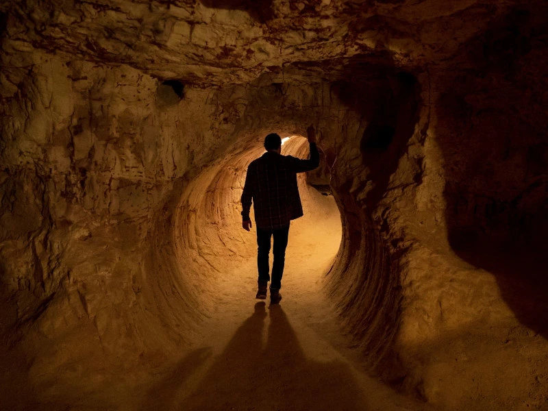 Person geht durch Höhlengang, Coober Pedy, Australien.