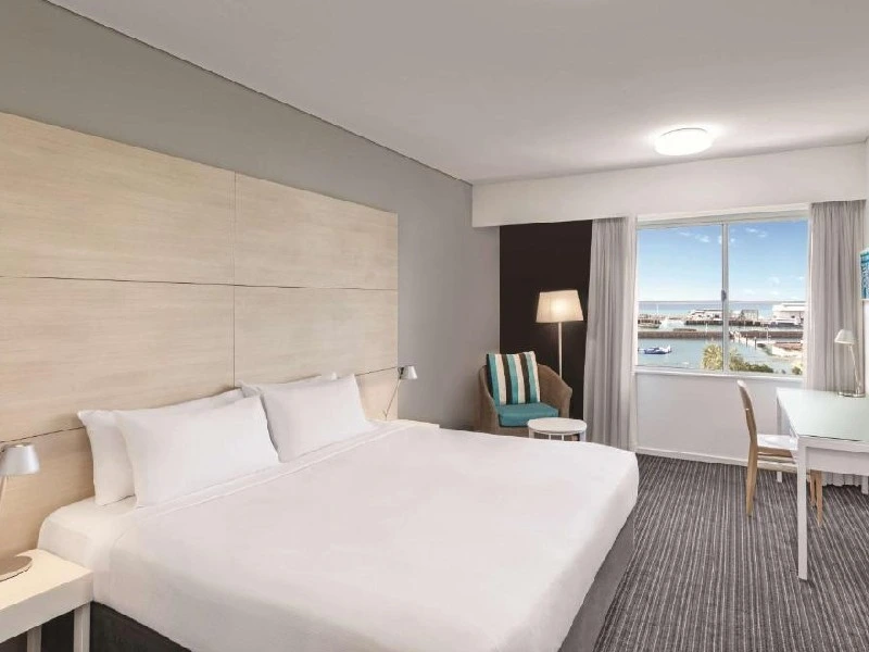 Bett und Schreibtisch im Hotelzimmer mit Blick aufs Wasser