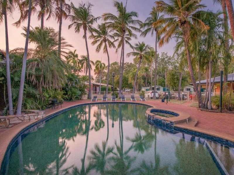 Hotelpool umgeben von Liegen und Palmen in Katherine, Australien