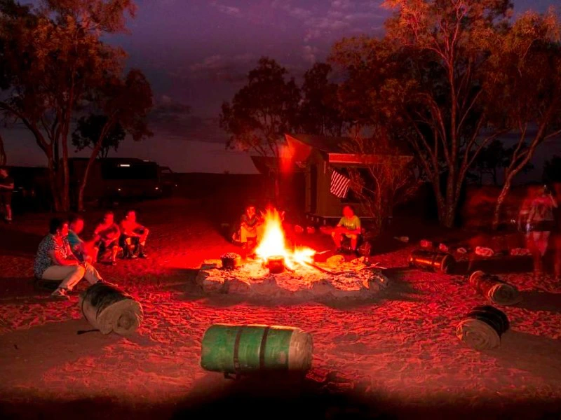Gruppe sitzt am Lagerfeuer auf einem Campingplatz im Outback, Australien.