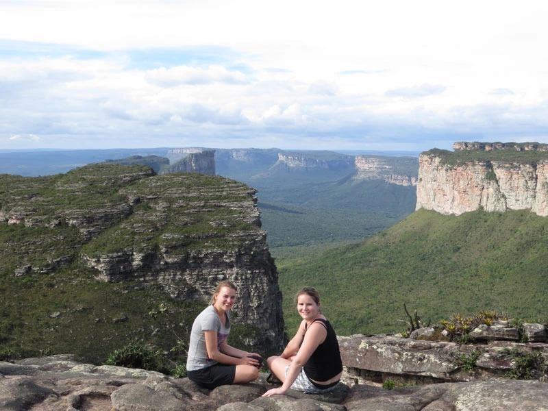 Zwei Reisende sitzen auf dem Rand des Chapada Diamantina Canyons in Brasilien