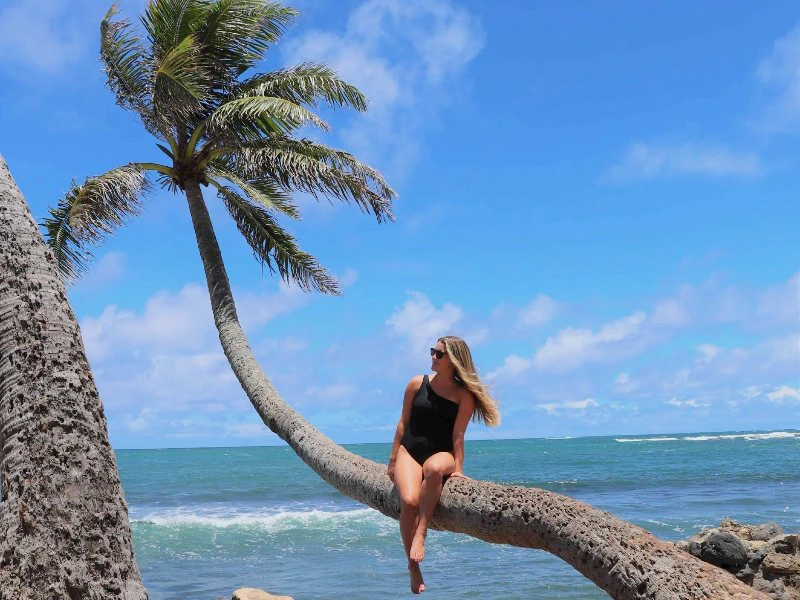 Frau auf Palme in Tinhare in Brasilien