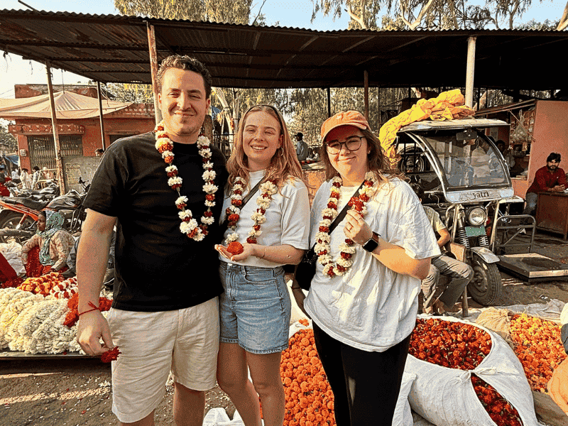 Touristen mit Blumenkette auf einem Markt in Jaipur, Indien