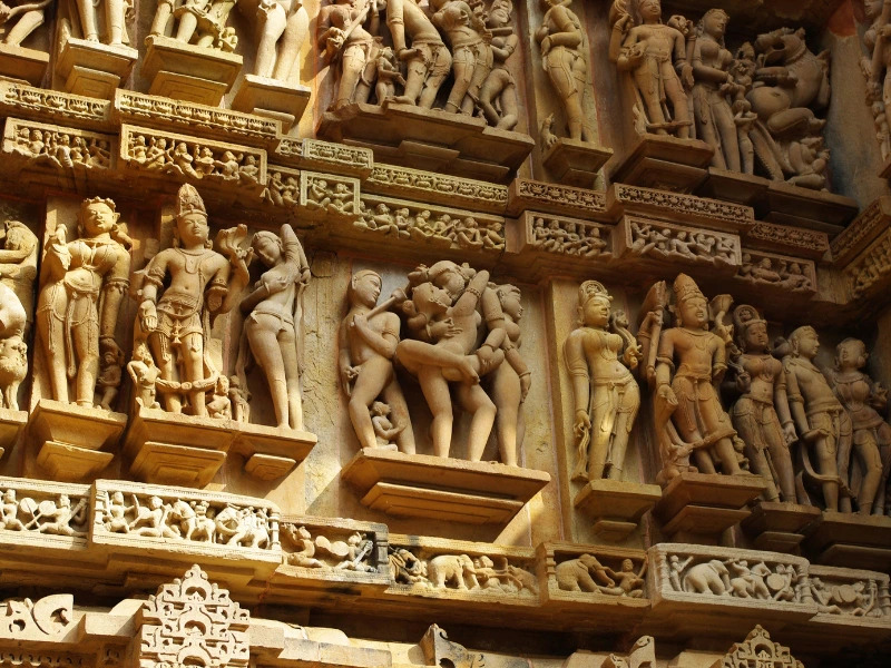 Figuren an den Wänden in den Tempeln in Khajurao in Indien
