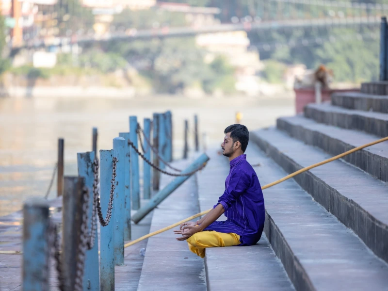 Meditierender Einheimischer am Fluss in Rishikesh
