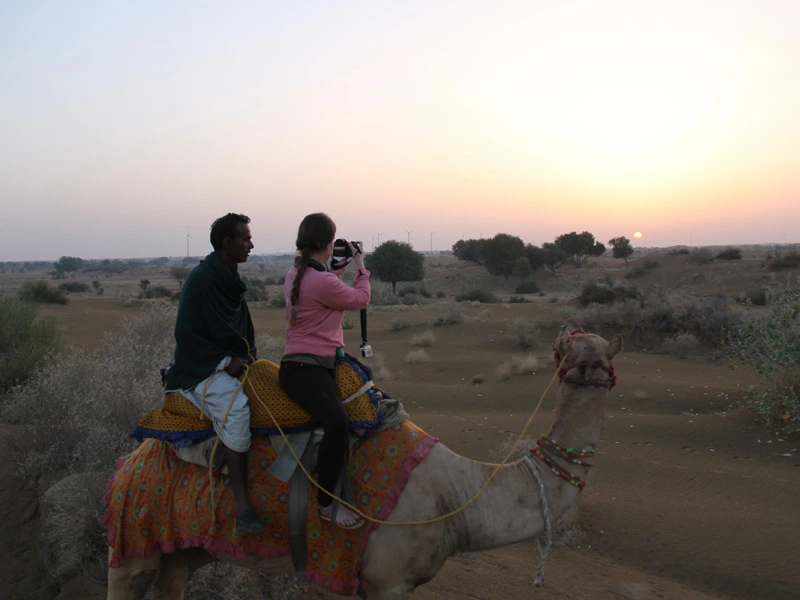 Sonnenaufgang auf dem Kamel in der Wüste in Jaisalmer auf einer Rundreise durch Indien