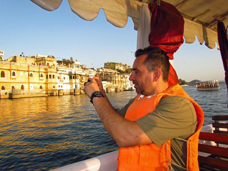 Tourist macht ein Foto währen der Bootstour auf dem Pichola See in Udaipur