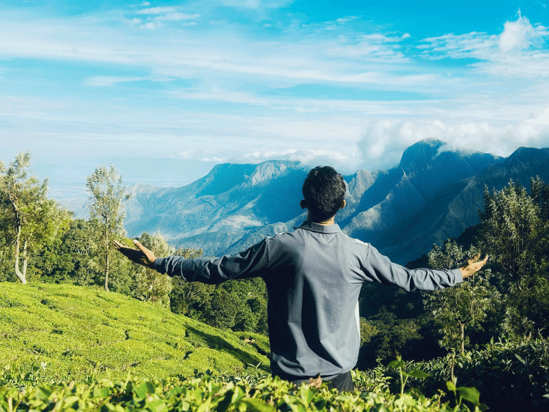 Touristen genießt die Aussicht in den Teeplantagen in Munnar, Indien