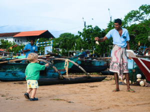 Junge mit Fischer am Strand in Indien