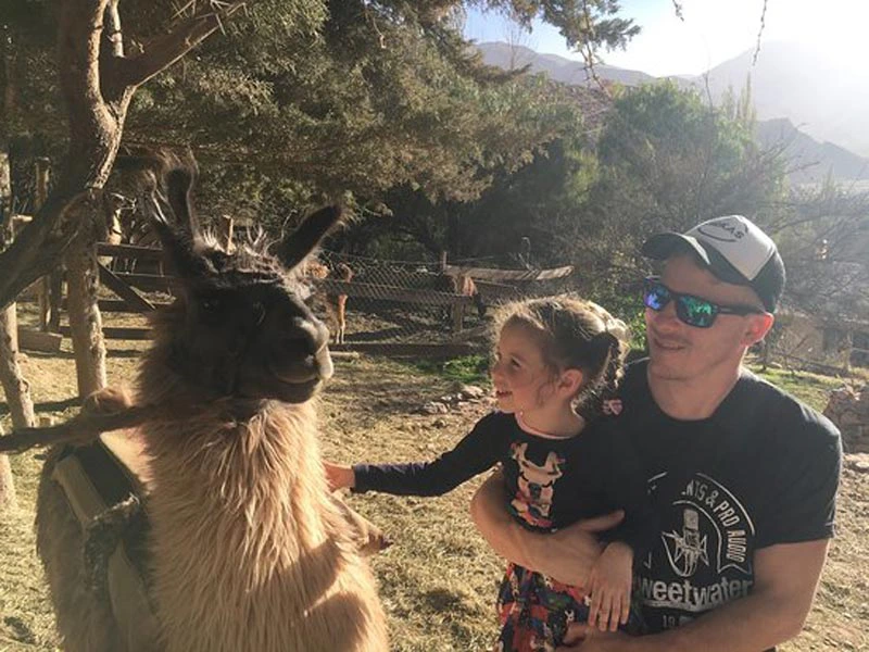 Vater mit Kind beim Lama Streicheln in Argentinien