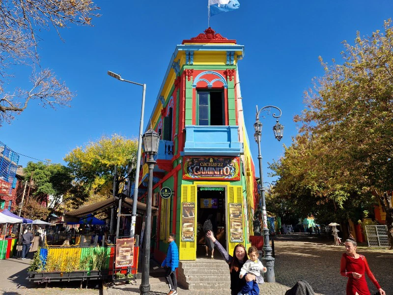 Reisende im Künstlerviertel in Buenos Aires vor einem bunten Haus