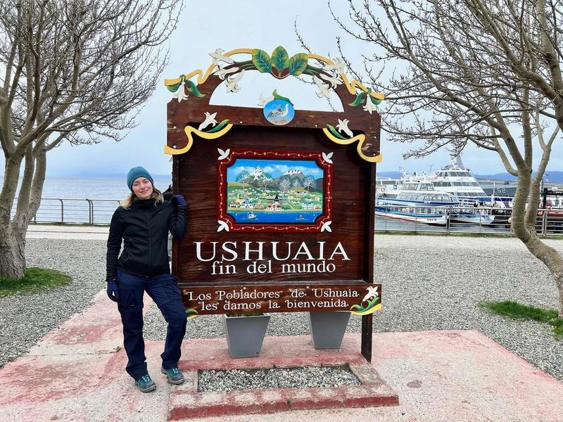 Frau am Ende der Welt Schilt in Ushuaia