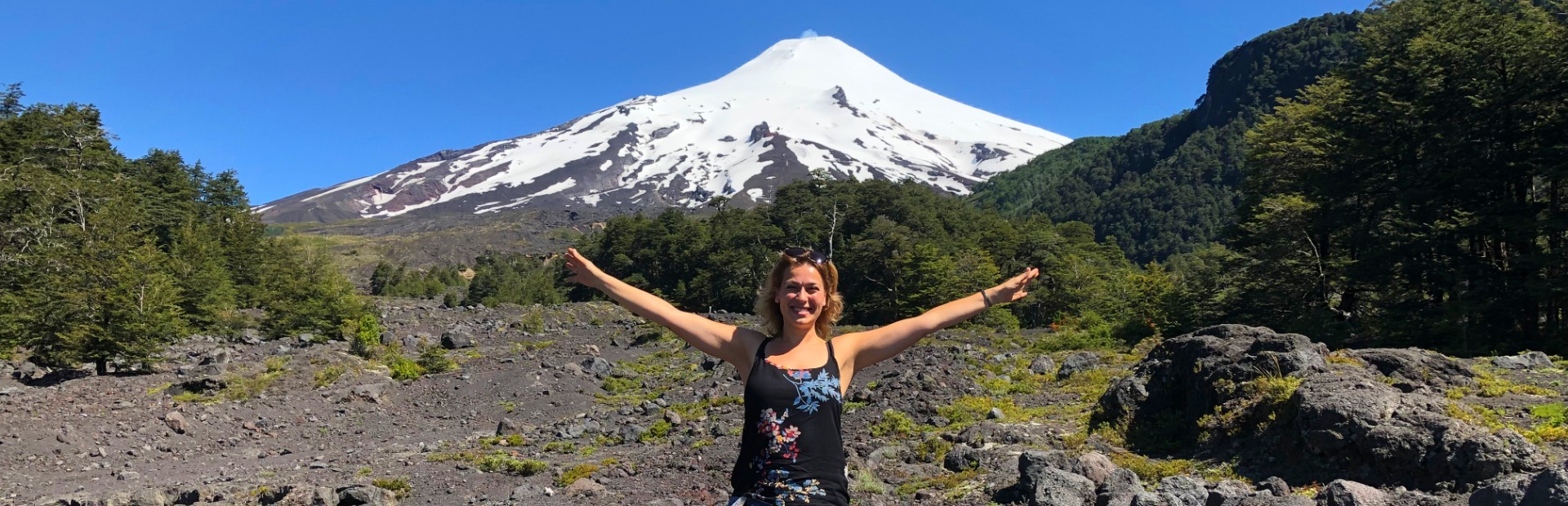 Frau vor schneebedecktem Vulkan in Chile