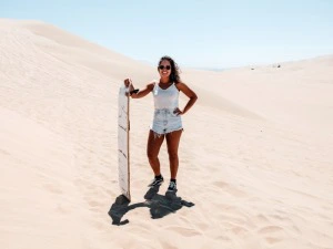 Frau mit Board in den Sanddünen bei San Pedro de Atacama in Chile