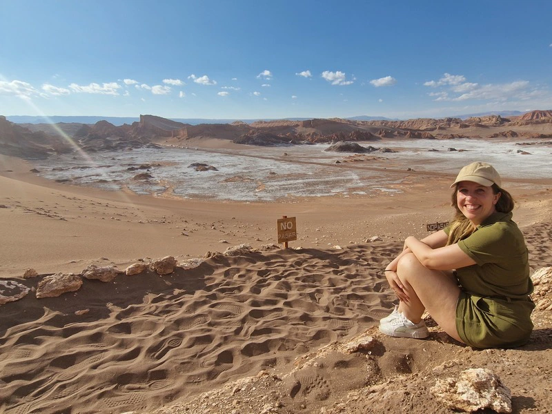 Frau sitzt in der Atacama Wüste