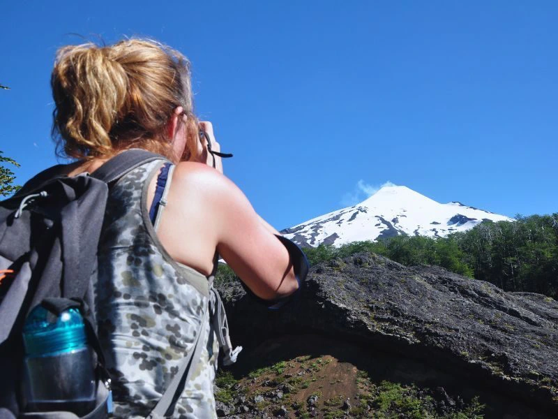 Frau betrachtet die Landschaft durch ein Fernglas