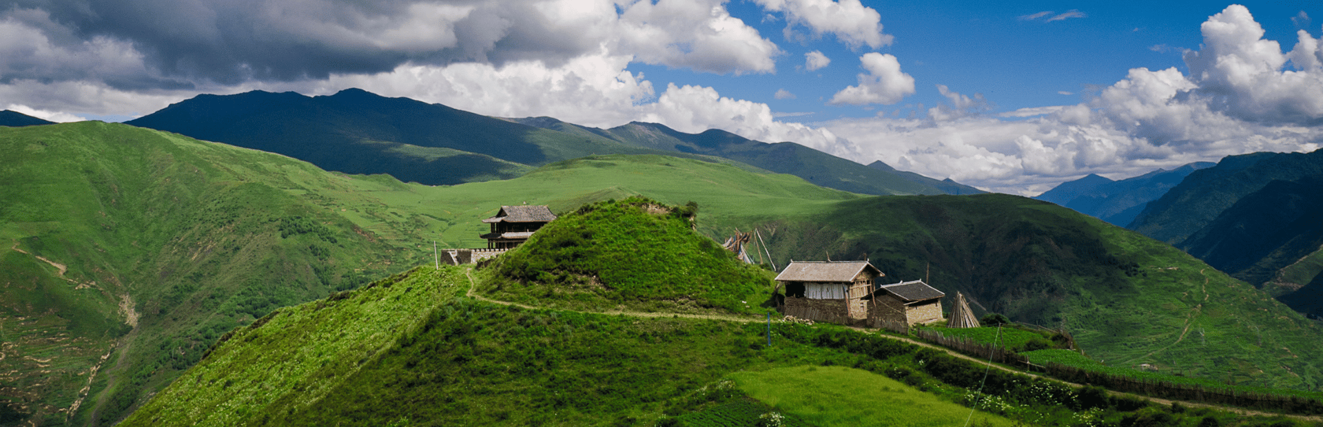 Grüne Wiese mit Häusern in Langmusi, China