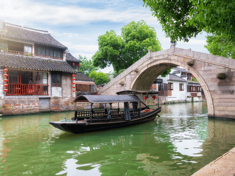 Boot fährt durch Brücke auf dem Kanal in Tongli, China