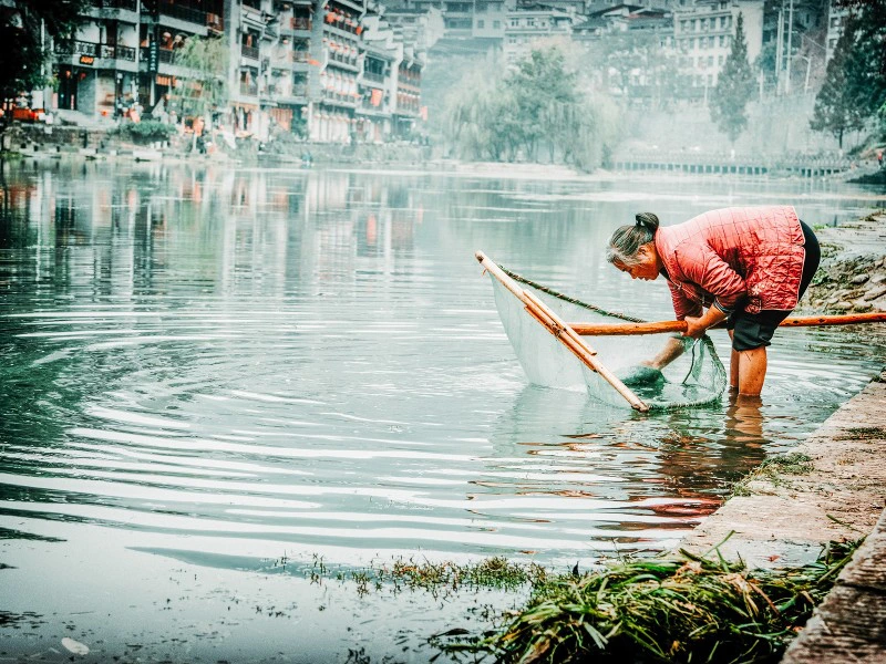 Fischerin am Fluss in Shanghai in China