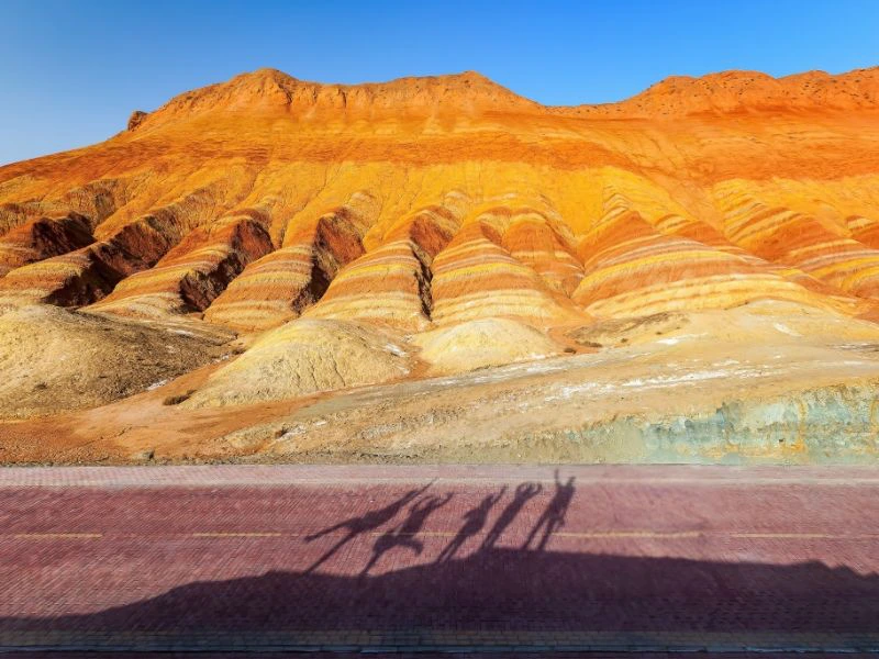 Schatten von Menschen vor der Zhangye Regenbogenbergen in China