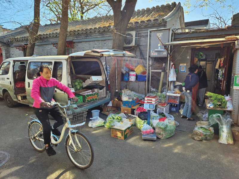 Einheimische mit dem Fahrrad in den Hutongs von Peking