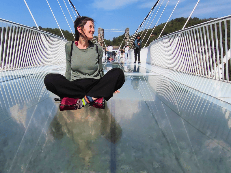 Reisende auf der Glasbrücke über den Grand Canyon von Zhangjiajie