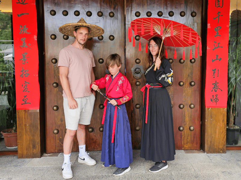 Familie vor dem Einfang eines traditionellen Gebäudes in China