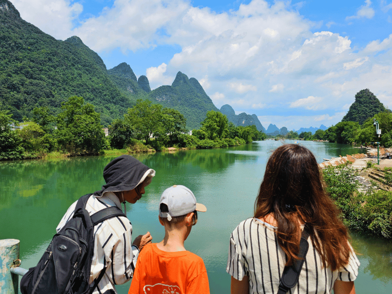 Familie und Guide genießen Aussicht auf die Karstberge in Yangshuo
