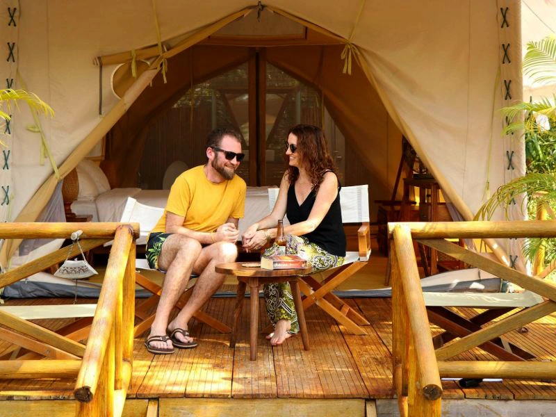 Paar sitzt vor einem Glamping Zelt in den Cardamom Bergen in Kambodscha