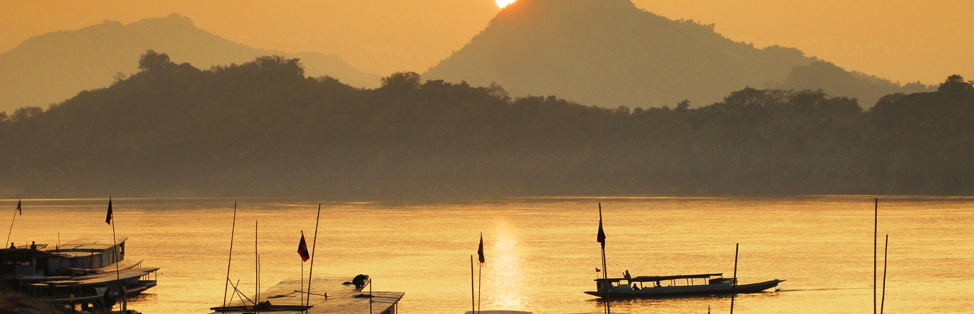 Boote treiben auf dem Mekong bei Sonnenuntergang in Kambodscha