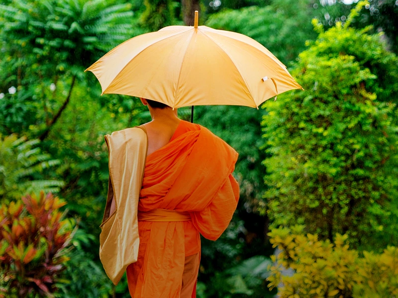 Mönch mit Regenschirm in Laos
