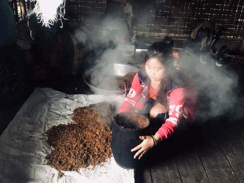 Laotin bei der Herstellung von Reiswein in Vang Vieng Laos