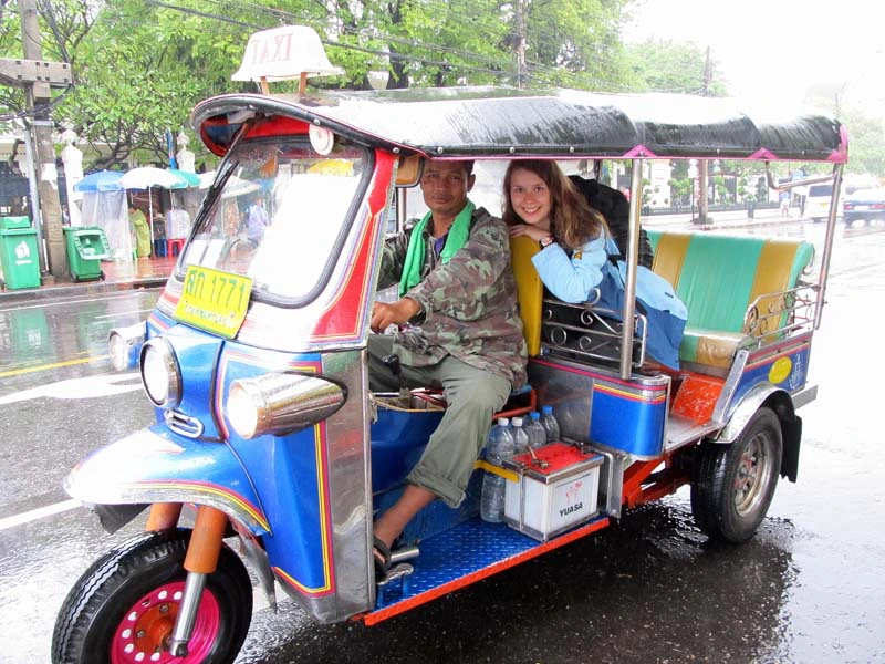 Tourist und Fahrer in einem bunten Tuk Tuk in Bangkok