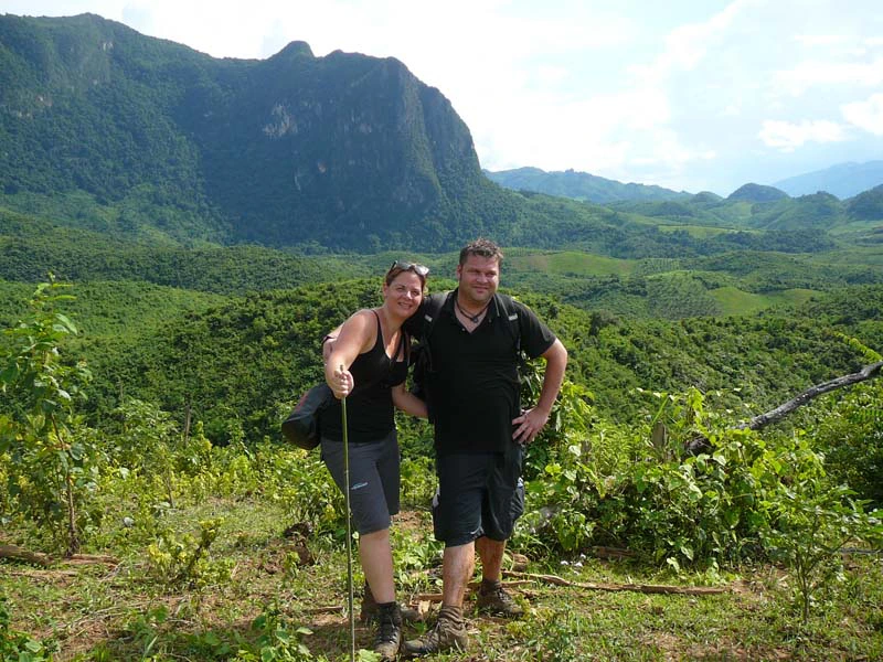 Touristen in der grünen Landschaft beim Trekking in Laos