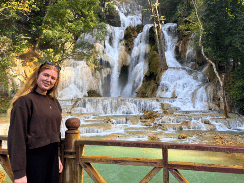 Frau vor einem Wasserfall in Kuang Si in Laos